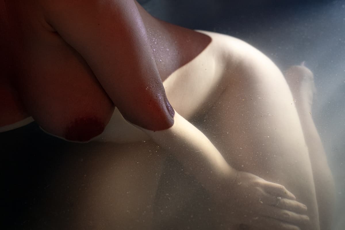 pregnant woman immersed in water, floating symbolising surrender and connection