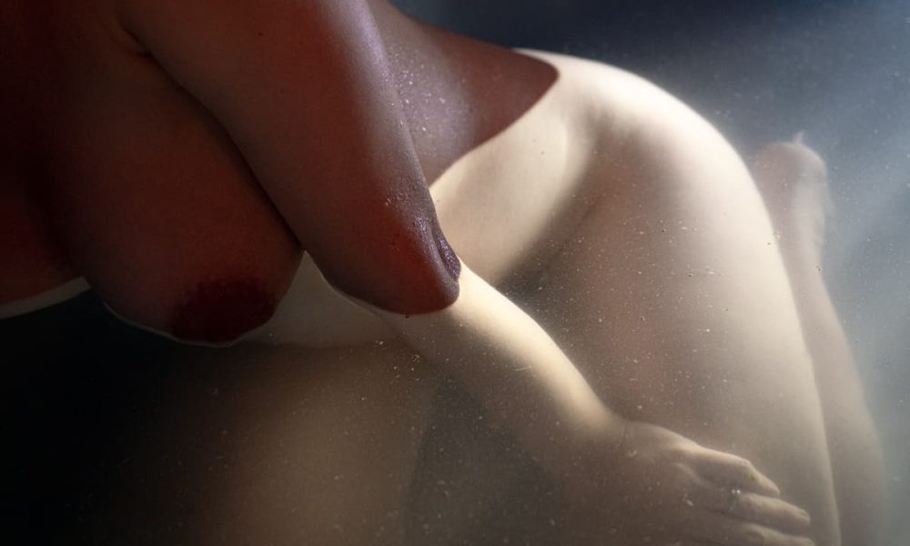 pregnant woman immersed in water, floating symbolising surrender and connection